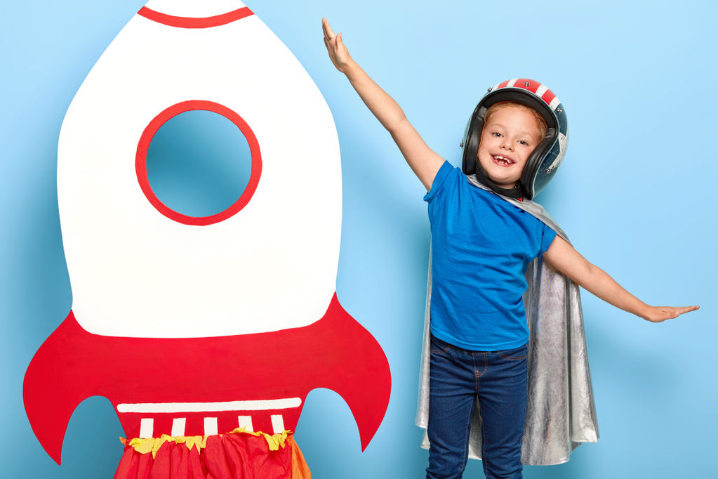 cute-happy-female-child-plays-astronaut-wears-flying-helmet-and-cape.jpg